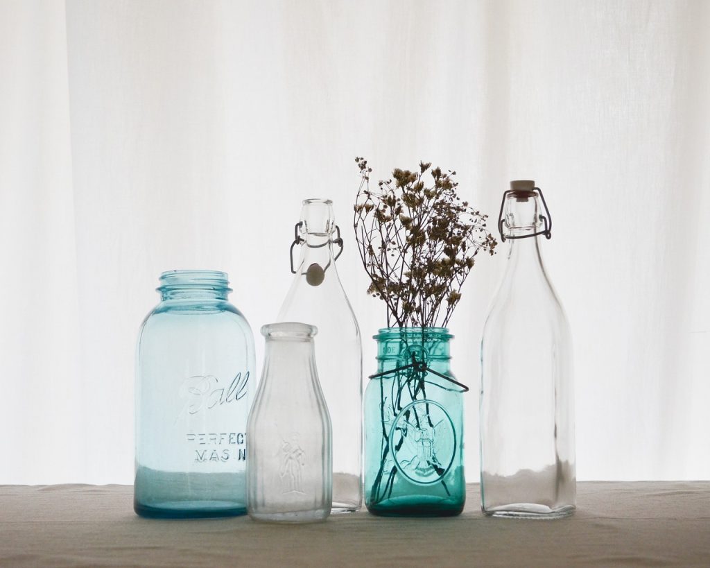 Empty glass jars and bottles on a table